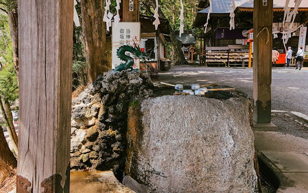 Arakurayama Sengen Park purification fountain with dragon statue and traditional ladles.