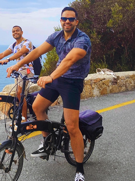 Two people riding e-bikes along a coastal road on Princes Island, Istanbul.
