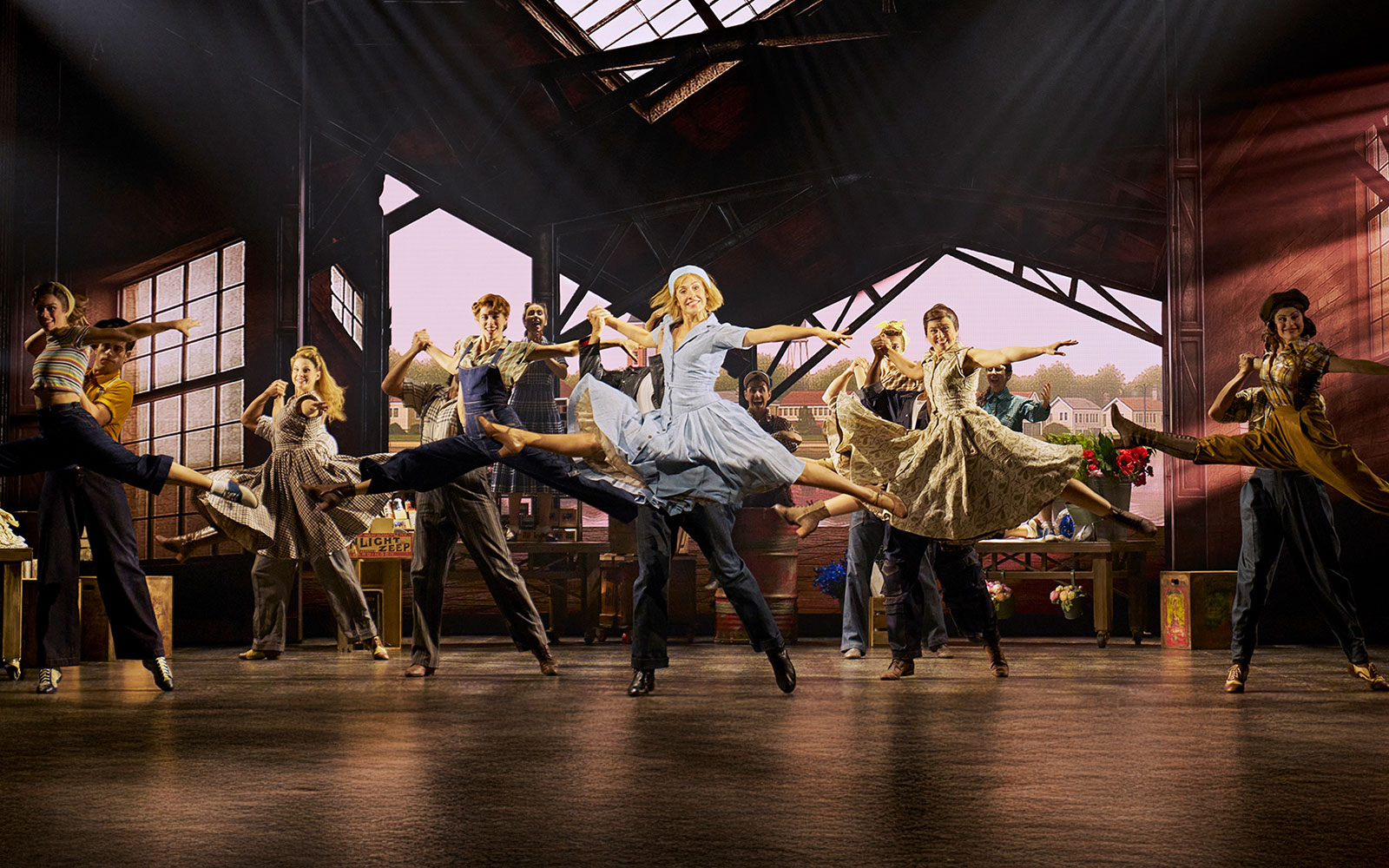 Cinderella stage performance in Madrid with dancers mid-leap in a vibrant scene.