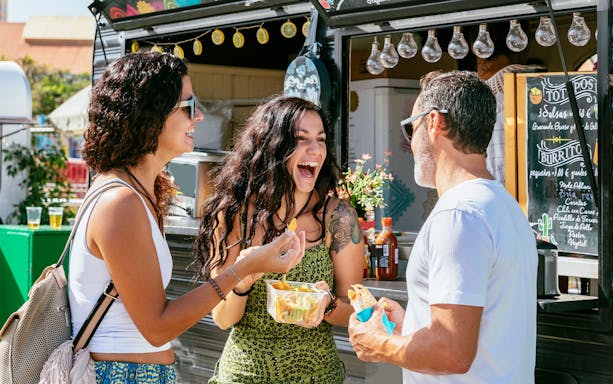 People enjoying street food at a vendor during a guided culinary tour in St. Pauli.