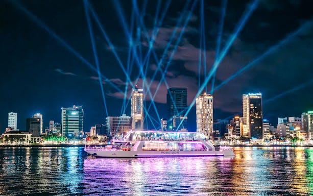 Da Nang Poseidon cruise with city skyline and colorful lights at night.