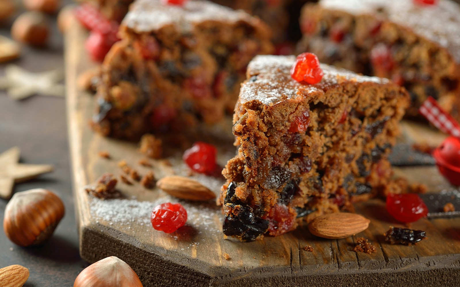 Traditional English Christmas fruit cake with marzipan and icing on a wooden table.