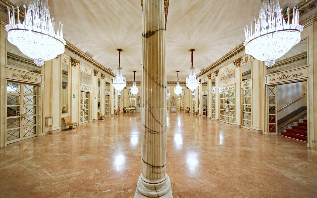 La Scala Theatre's opulent foyer with chandeliers and marble columns, Milan.