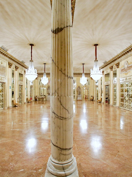 La Scala Theatre's opulent foyer with chandeliers and marble columns, Milan.
