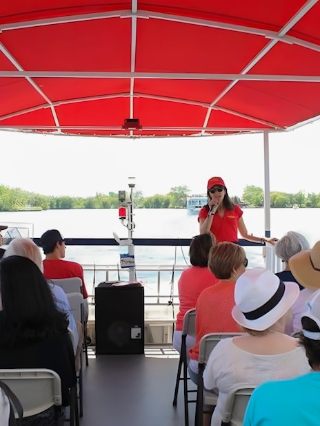 Tour guide speaking to passengers on a Toronto Harbour cruise boat.