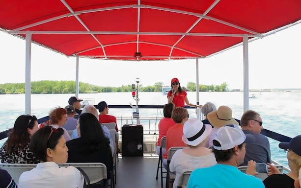 Tour guide speaking to passengers on a Toronto Harbour cruise boat.