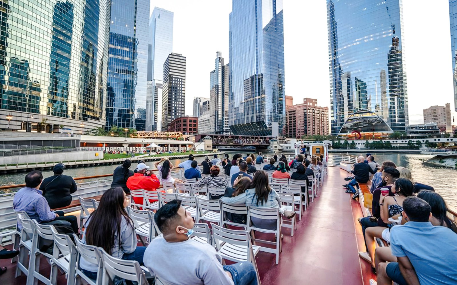 Chicago River cruise boat with passengers enjoying views of Lake Michigan skyline.
