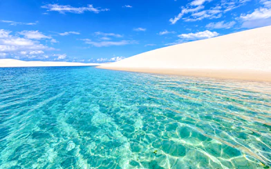 Clear lagoon with sand dunes at Lagoa Bonita, Barreirinhas, Brazil.