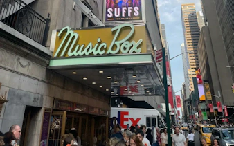 Music Box Theatre entrance on Broadway, New York, with people walking nearby.