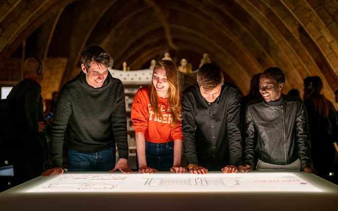 Guests exploring interactive display at La Pedrera Casa Mila night tour.