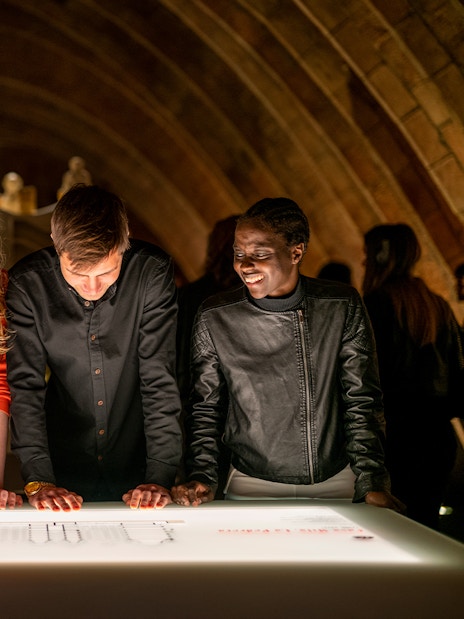 Guests exploring interactive display at La Pedrera Casa Mila night tour.