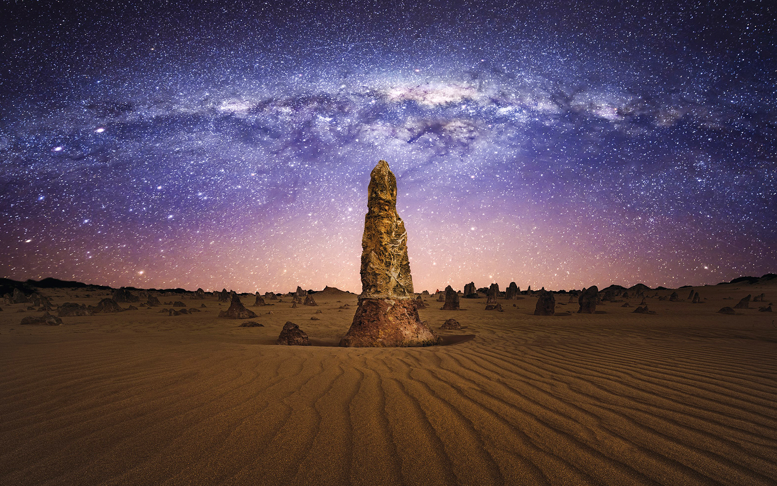 Pinnacles Desert under starry sky during sunset, Western Australia.