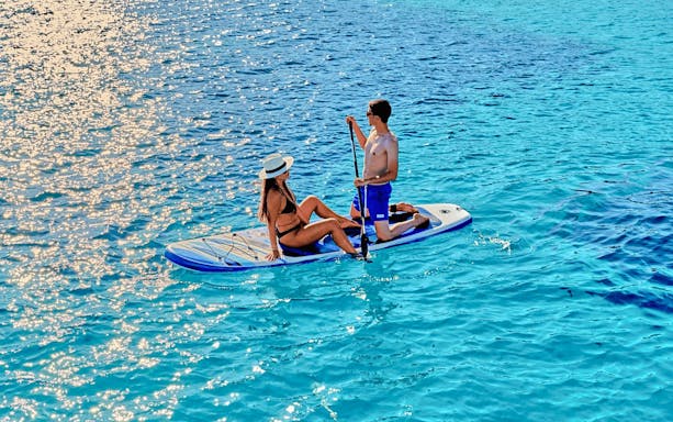 Paddleboarding on clear waters during a luxury catamaran cruise near Chrissi Island.