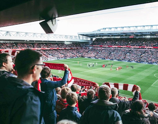 Fans watching a match at Liverpool FC's Anfield Stadium.
