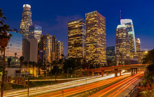 Los Angeles downtown skyline with illuminated buildings during holiday lights tour.