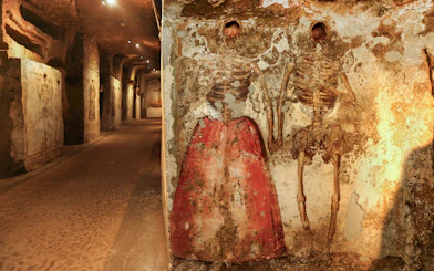 Skeletons in Catacombs of San Gaudioso, Naples, with painted clothing on walls.