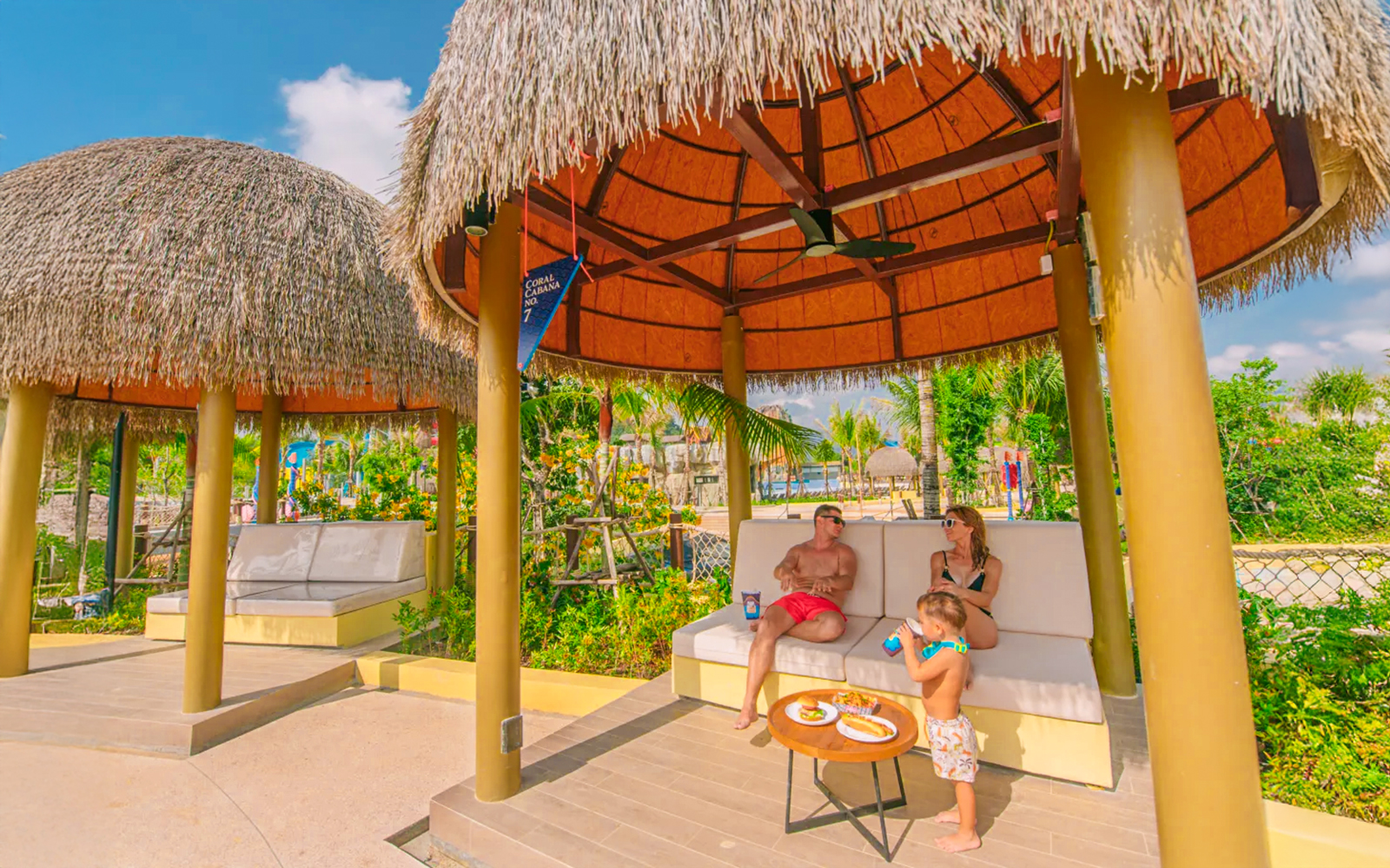 Family relaxing in a thatched cabana at Coral Cabana, Andamanda Phuket.