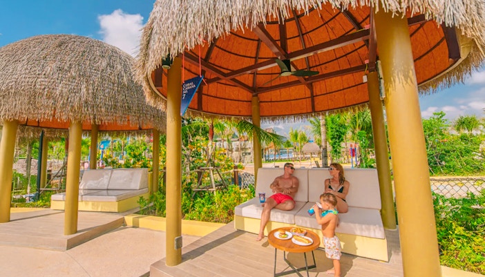 Family relaxing in a thatched cabana at Coral Cabana, Andamanda Phuket.