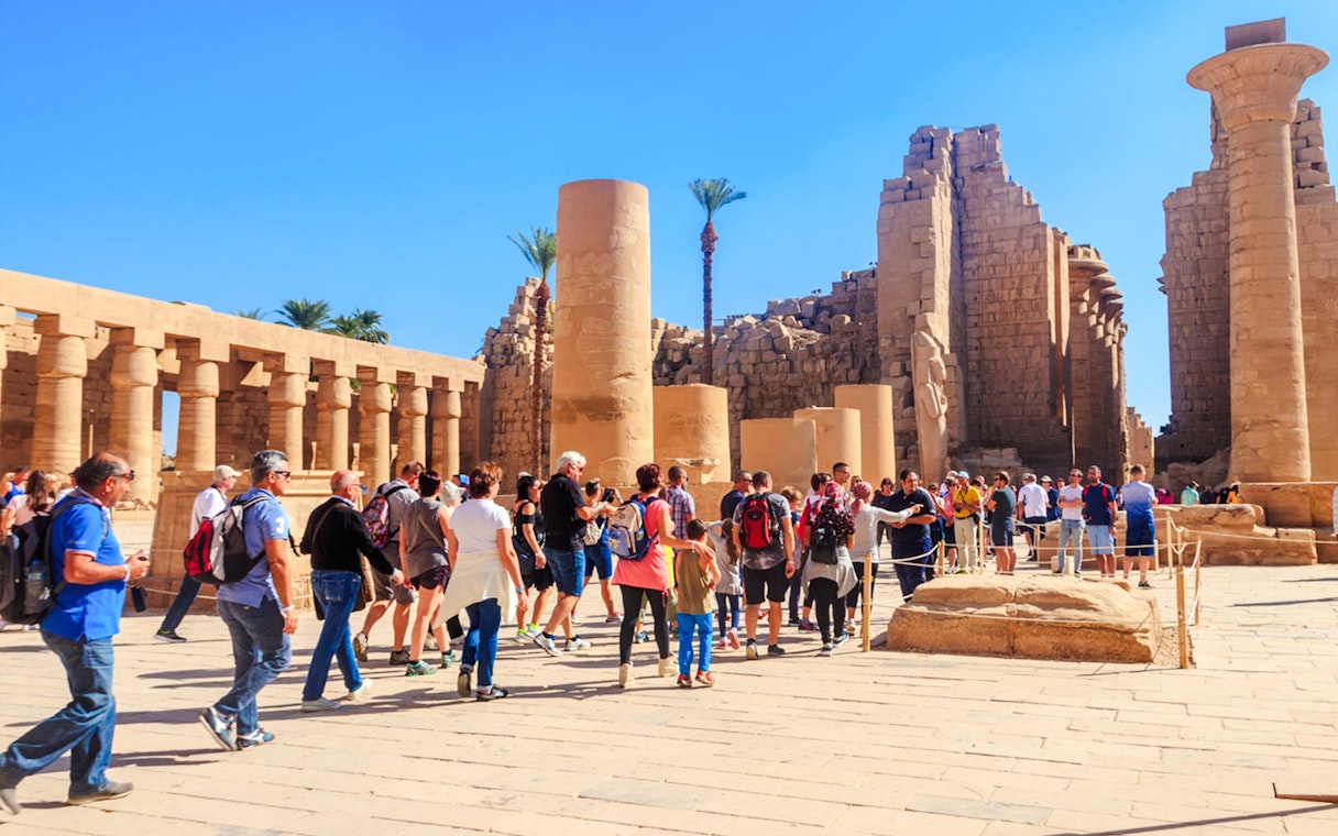 Visitors exploring Karnak Temple ruins during Luxor tour.