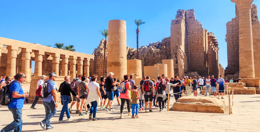 Visitors exploring Karnak Temple ruins during Luxor tour.