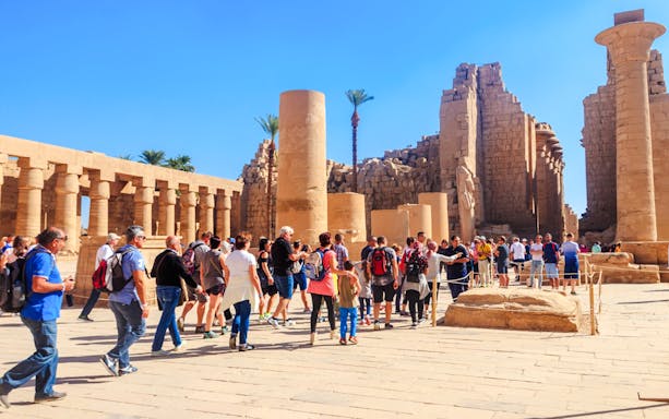 Visitors exploring Karnak Temple ruins during Luxor tour.