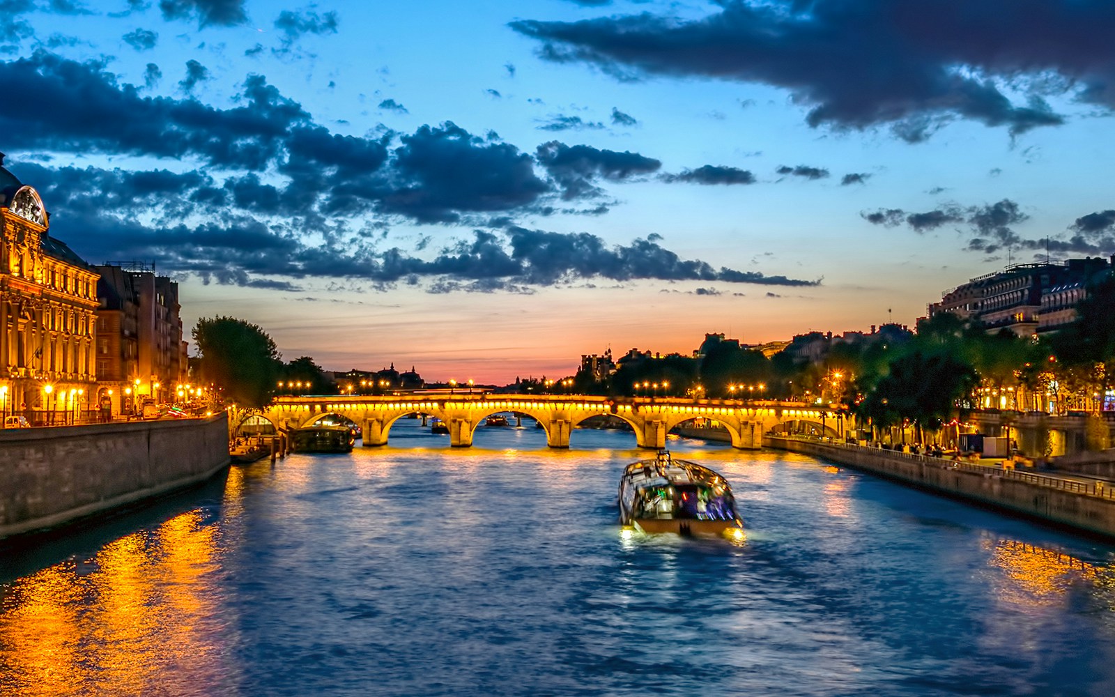 Conciergerie and Pont Neuf bridge Illuminated at night