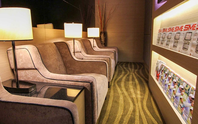 Plaza Premium Lounge seating area with armchairs and reading materials.