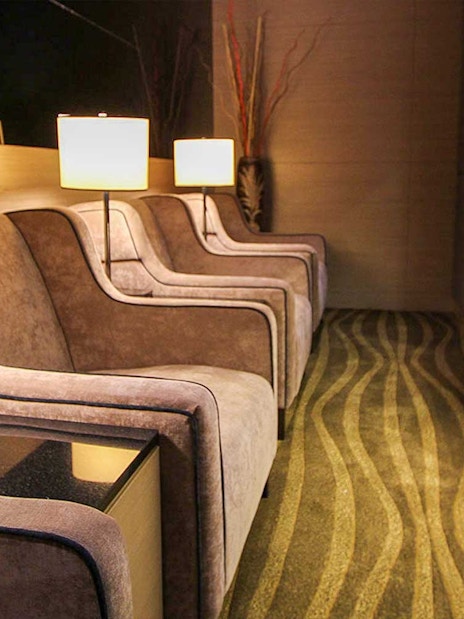 Plaza Premium Lounge seating area with armchairs and reading materials.