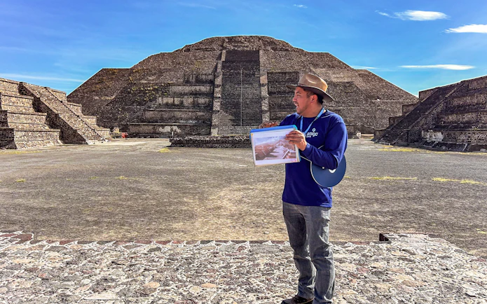Tour guide at Teotihuacan Pyramid, Mexico, explaining site details.