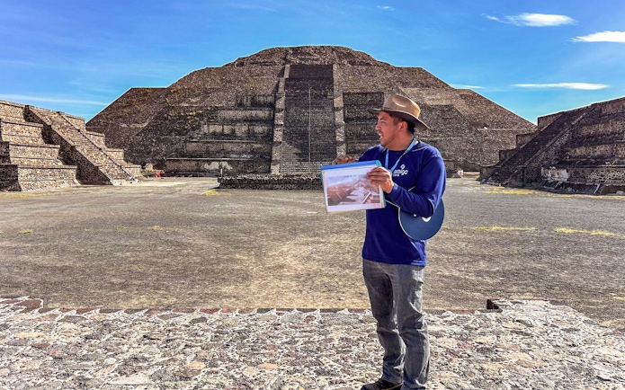 Tour guide at Teotihuacan Pyramid, Mexico, explaining site details.