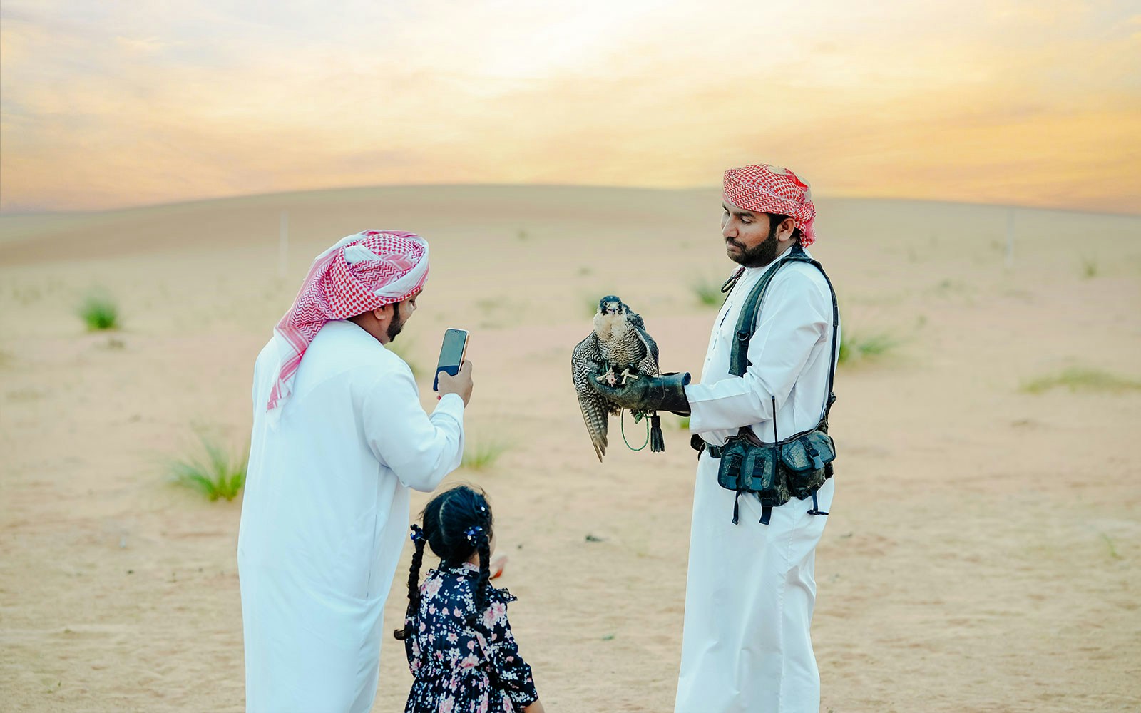 Falconer with falcon engaging guests at 57 Heritage Desert Safari in Dubai.