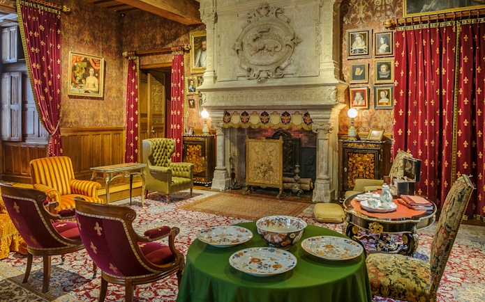 Biencourt salon at Azay-le-Rideau with ornate fireplace, vintage furniture, and decorative plates.