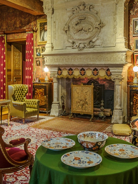 Biencourt salon at Azay-le-Rideau with ornate fireplace, vintage furniture, and decorative plates.