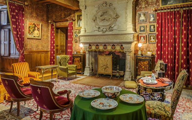 Biencourt salon at Azay-le-Rideau with ornate fireplace, vintage furniture, and decorative plates.