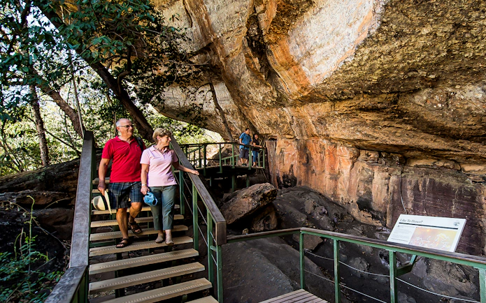 Visitors exploring rock art at Kakadu National Park during guided tour.
