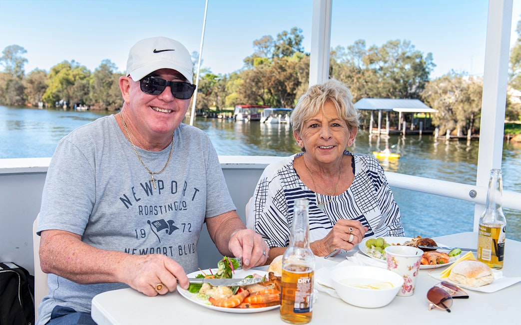 Couple enjoying lunch on a Murray River cruise with scenic river views.