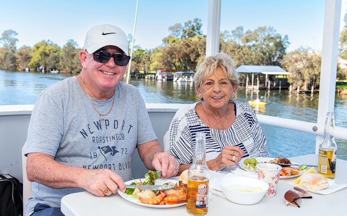 Couple enjoying lunch on a Murray River cruise with scenic river views.
