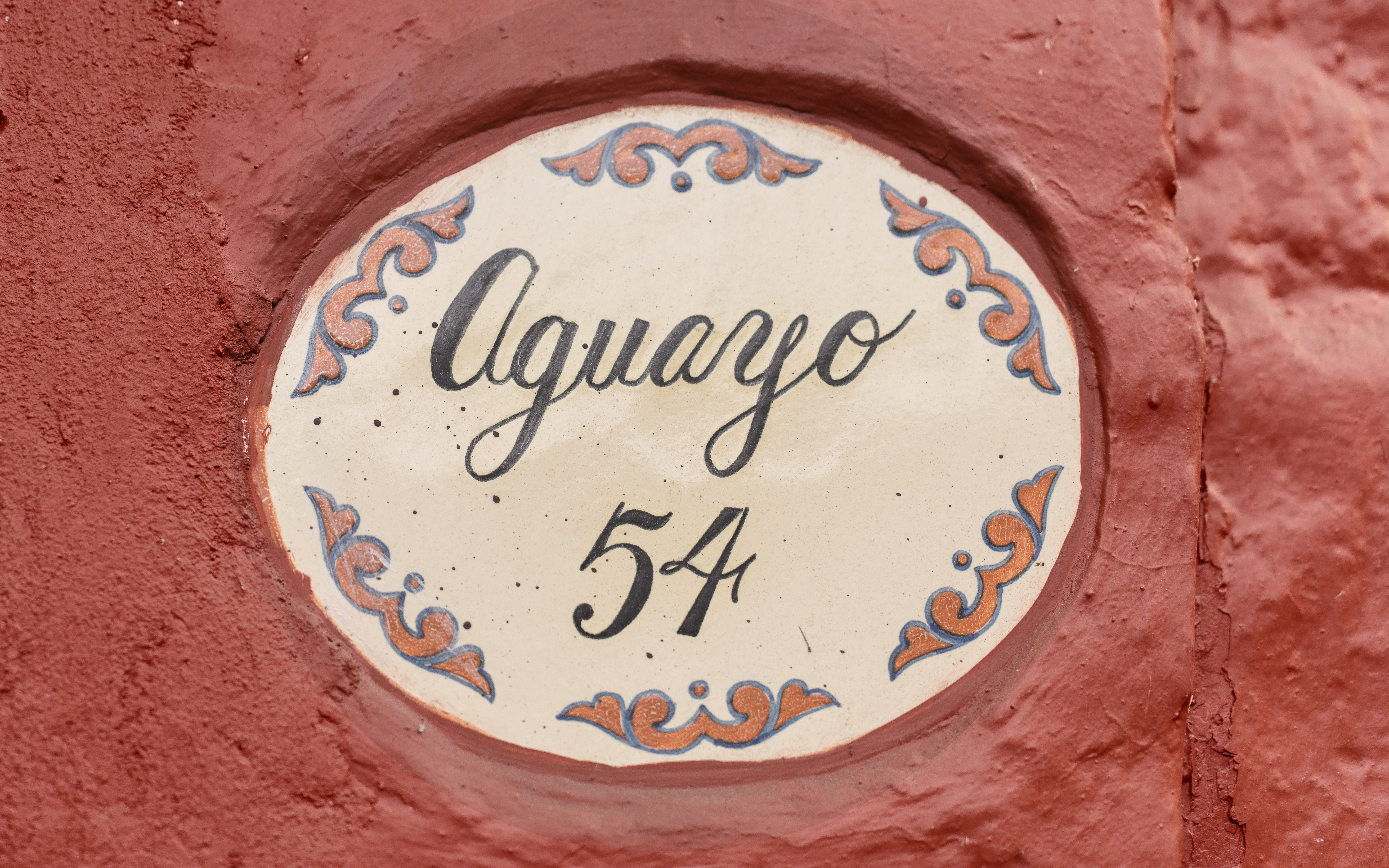 Aguayo 54 sign on red wall at Museo Casa Kahlo.