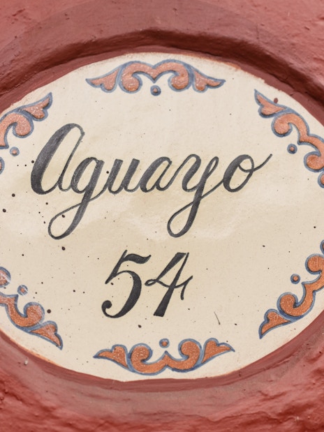 Aguayo 54 sign on red wall at Museo Casa Kahlo.
