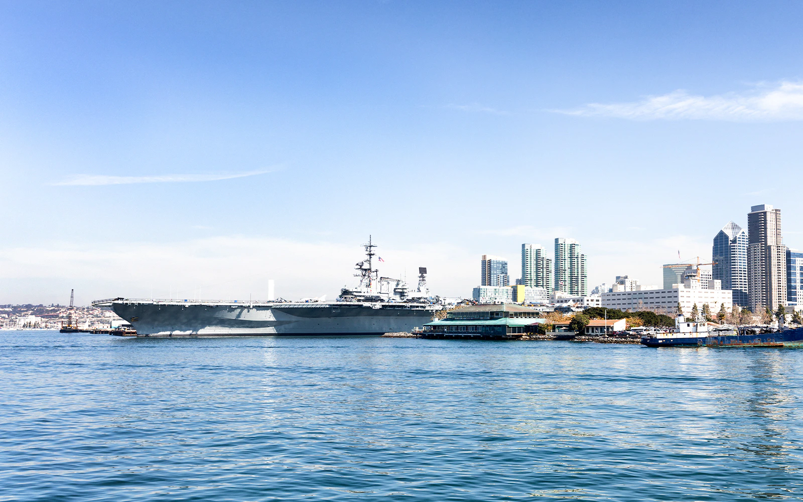 USS Midway Museum with San Diego skyline from a harbor cruise.