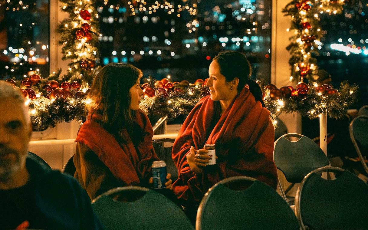 Two people enjoying a festive evening on the Circle Line Harbor Lights Cruise.