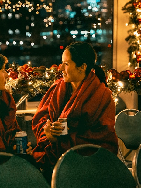 Two people enjoying a festive evening on the Circle Line Harbor Lights Cruise.