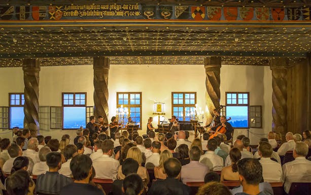 Concert audience at Fortress Hohensalzburg enjoying a Mozart performance.