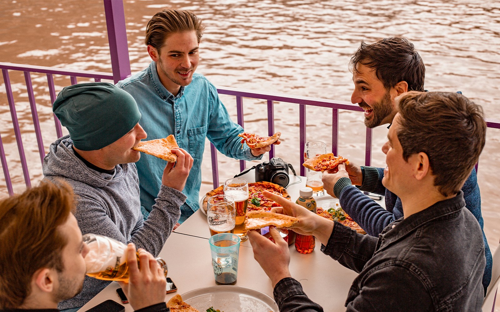 Group enjoying pizza and drinks on a Budapest party boat cruise.