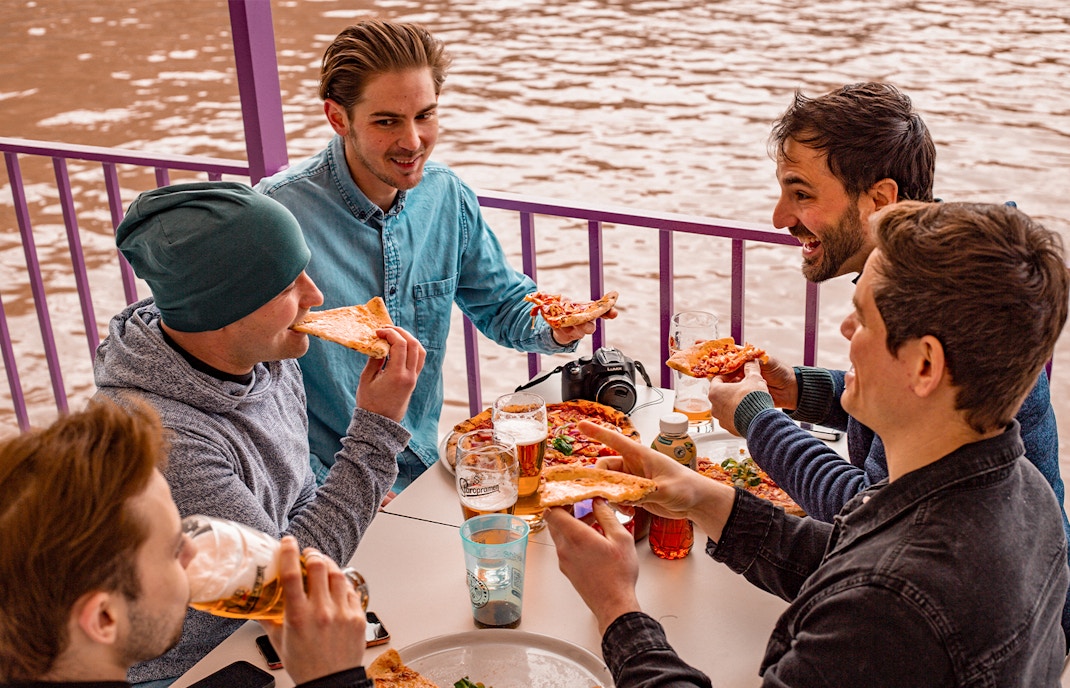 Danube River party boat cruise in Budapest with pizza and unlimited drinks.