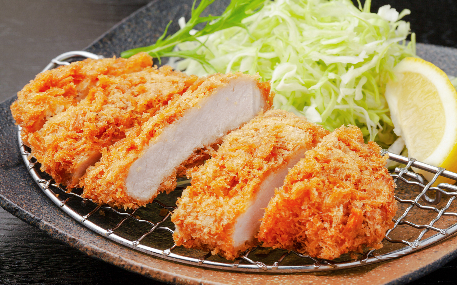 Rosu katsu dish served with shredded cabbage and dipping sauce in Tokyo, Japan.