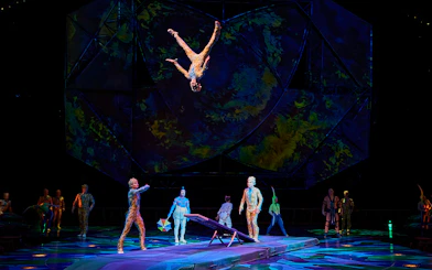 Acrobats performing a flip on stage during Mystère show.