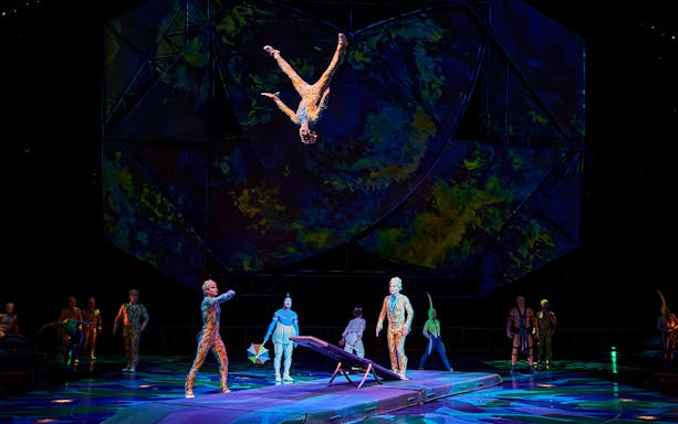 Acrobats performing a flip on stage during Mystère show.