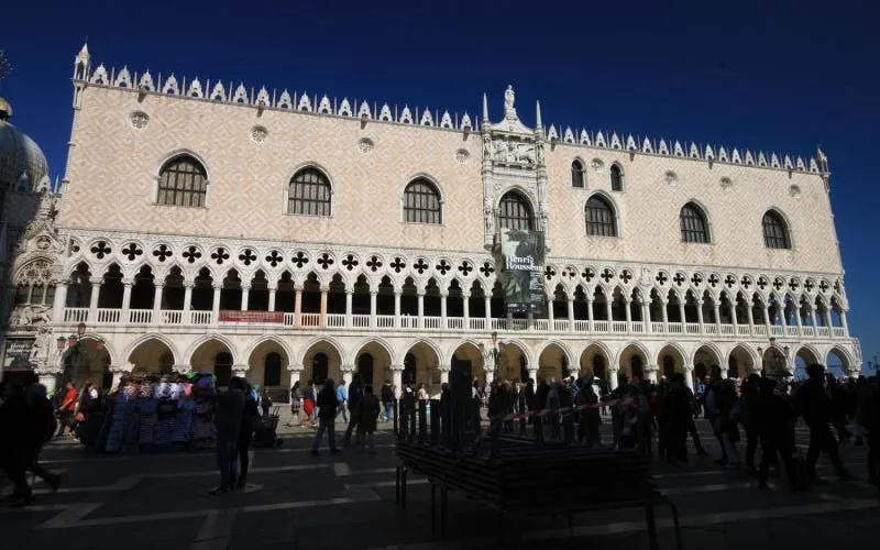Doge's Palace facade with tourists in Venice, Italy, part of skip-the-line guided tour.