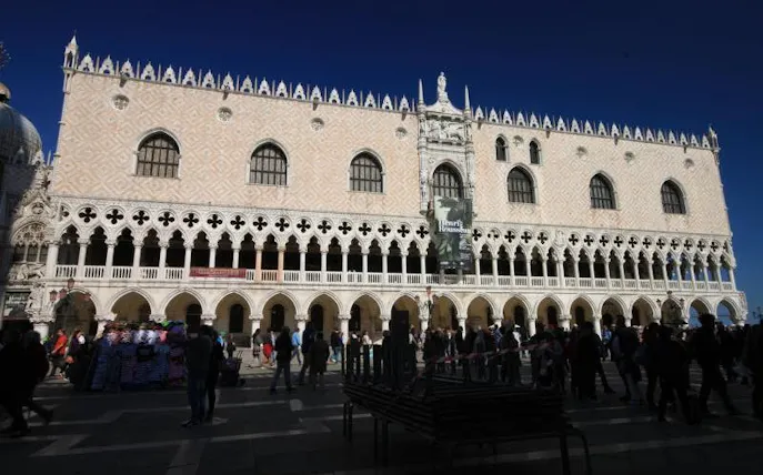 Doge's Palace facade with tourists in Venice, Italy, part of skip-the-line guided tour.